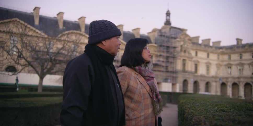 Couple holding hands walking in a public place in the late afternoon