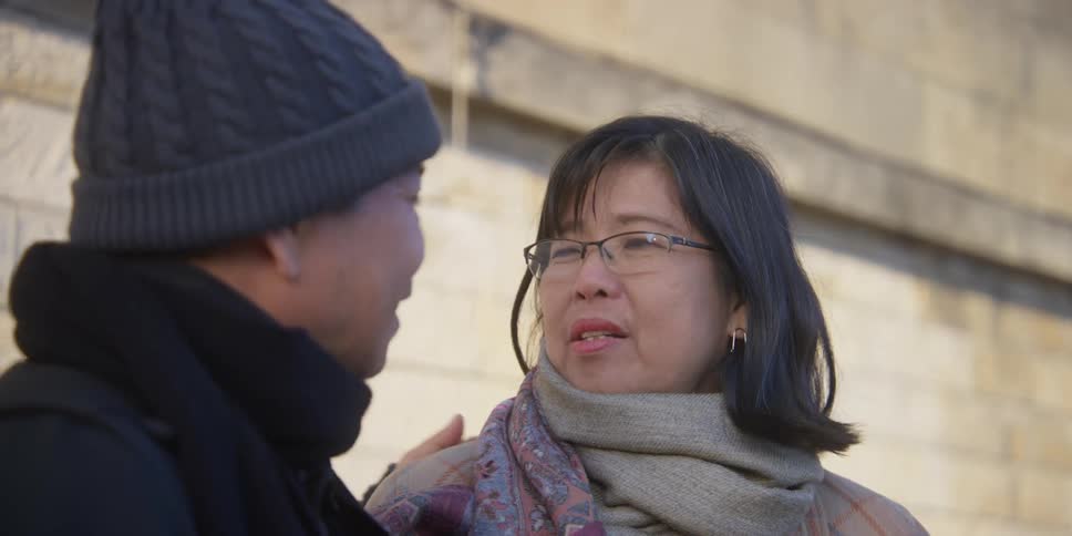 A man stroking the hair of a woman who is talking to him and they are both happy
