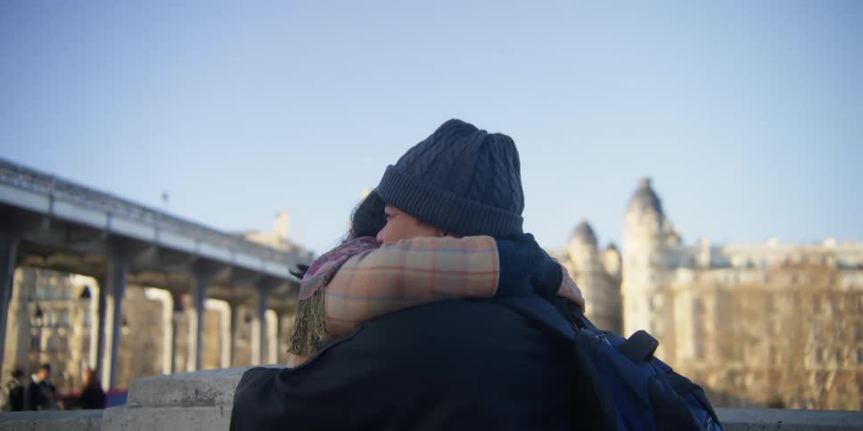 A couple visting paris hug on the streets