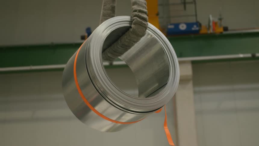 A roll of aluminum is hanging in the factory