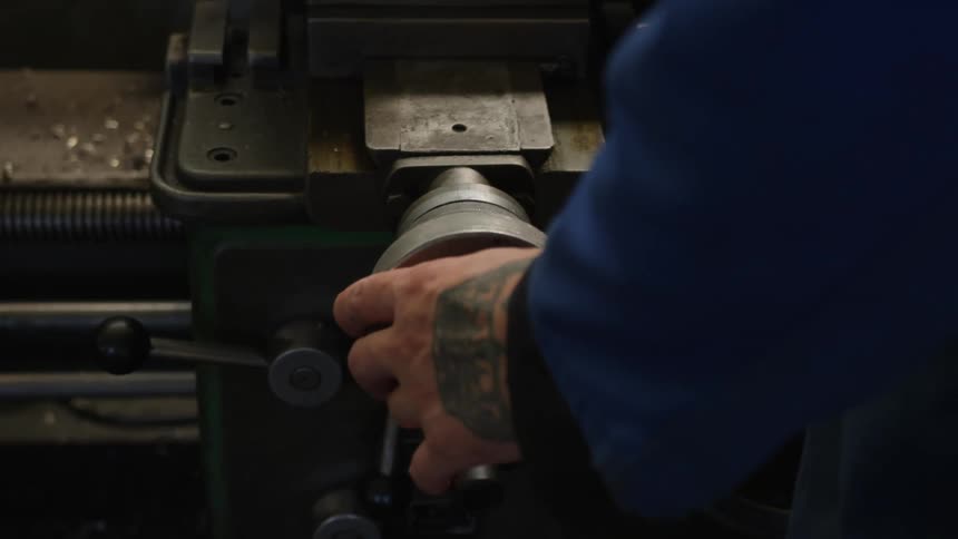Man standing in workshop operates machine