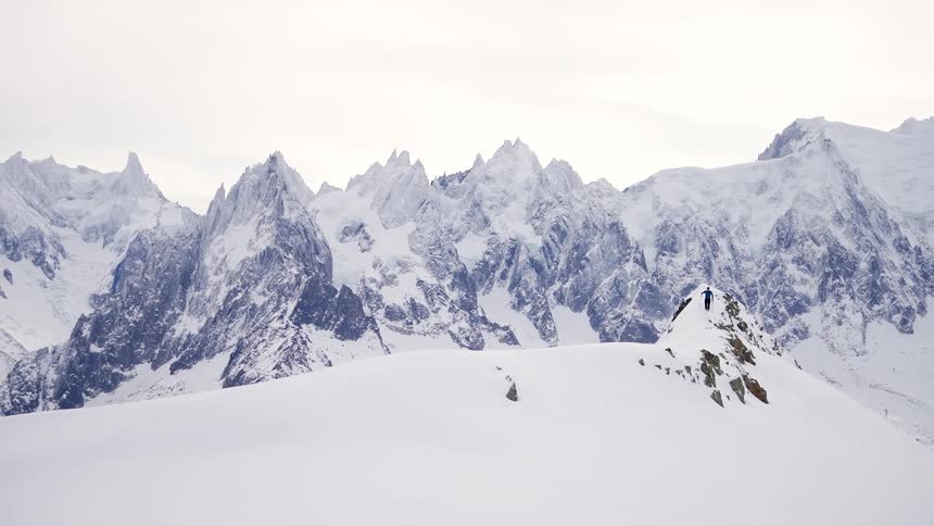 A person skis on a rock outcropping
