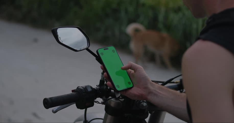 A person using a cell phone with a green screen