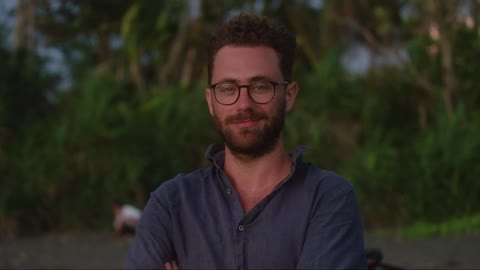 A man is smiling outside