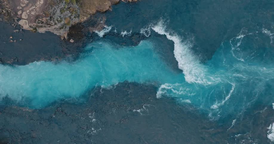 Top down aerial view of a river with different hues of water