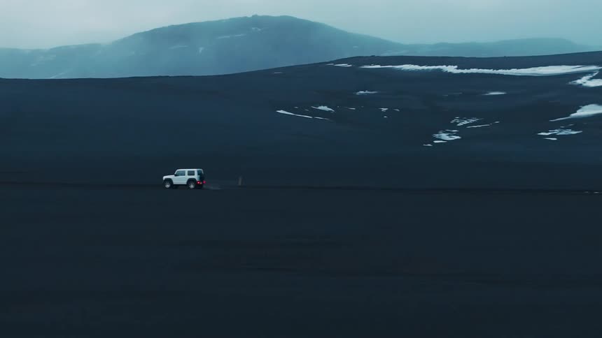 A vehicle crossing the desert during dusk