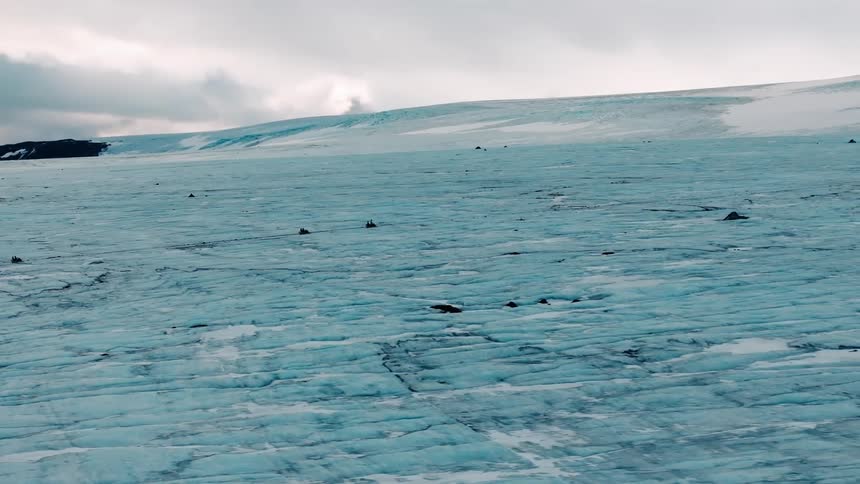 People driving vehicles on a glacial plain in the arctic