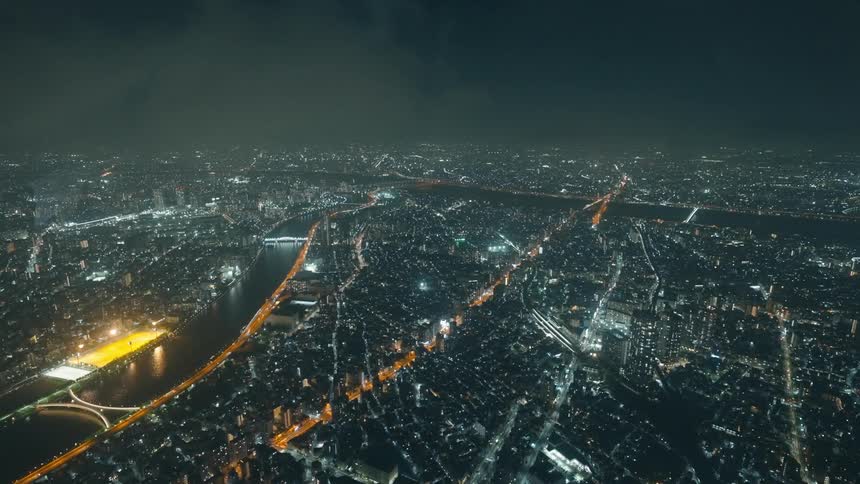 A night view of a sprawling urban landscape with a bright river