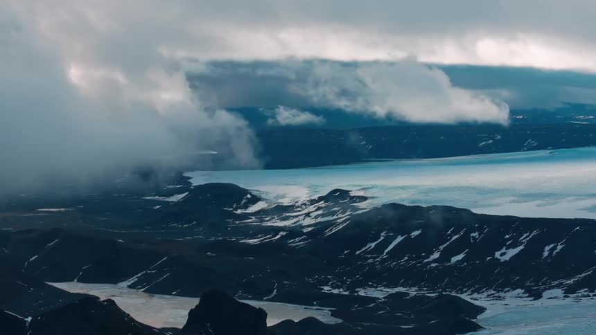 Clouds move over a vast coastal mountain range