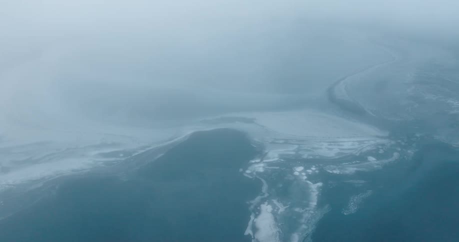 Aerial landscape of the extensive blue sea with ice on a cloudy day