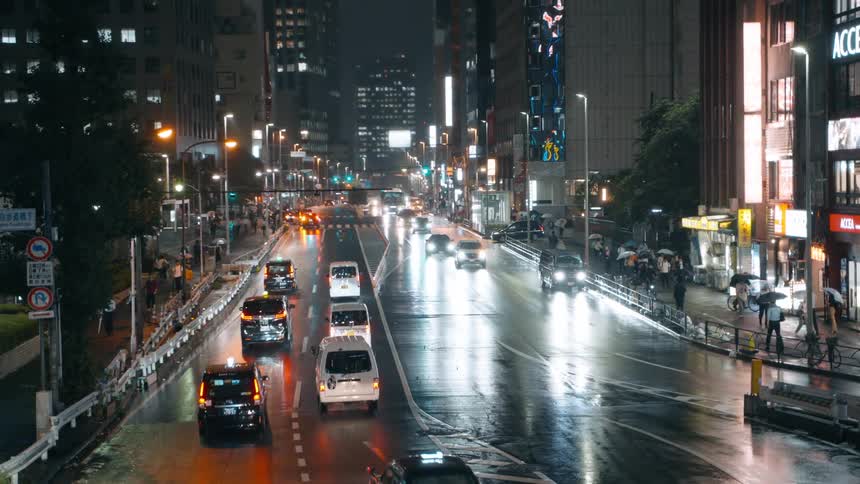 A nighttime city scene with taxis and illuminated signs