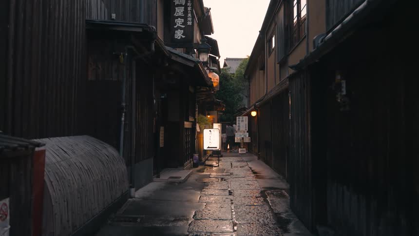 A narrow japanese alleyway with traditional wooden buildings and a lantern