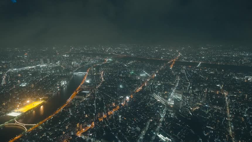 An aerial view of a major metropolitan area shows countless buildings with lights