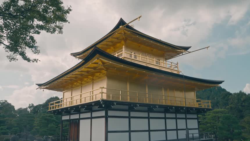 A traditional japanese pagoda with gold coloring and multiple tiers