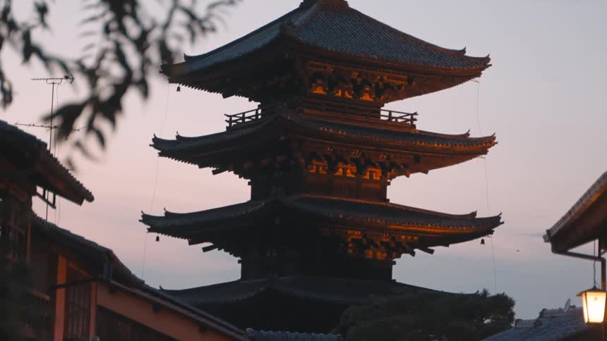 A pagoda towers over nearby buildings in Kyoto
