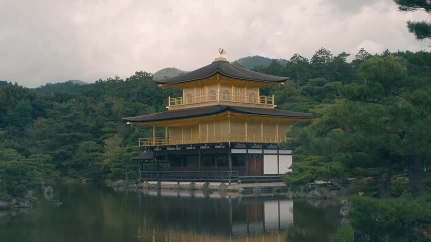A pagoda sits on a foundation next to a lake