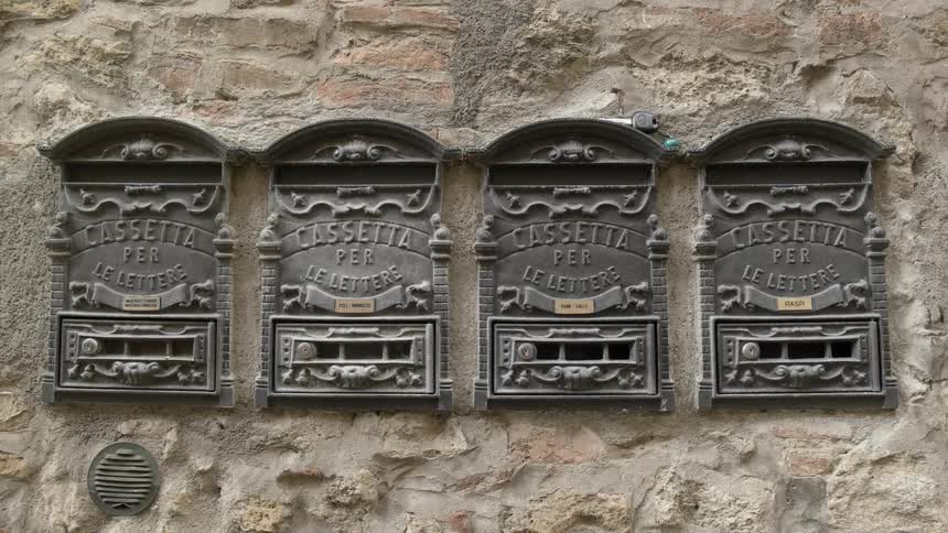 Four metal markers on a stone wall