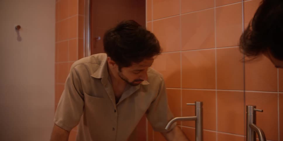 Man cleans tiled bathroom with a white cloth
