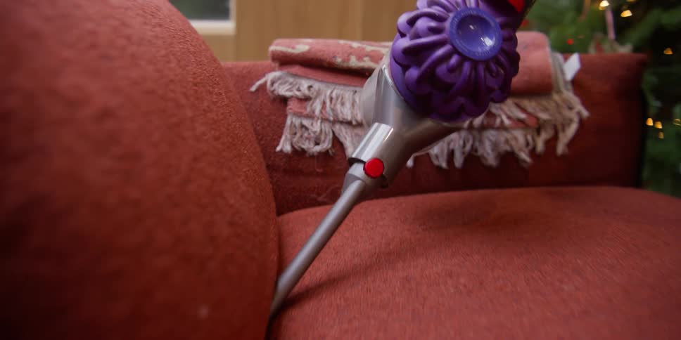A clip of a person cleaning the couch