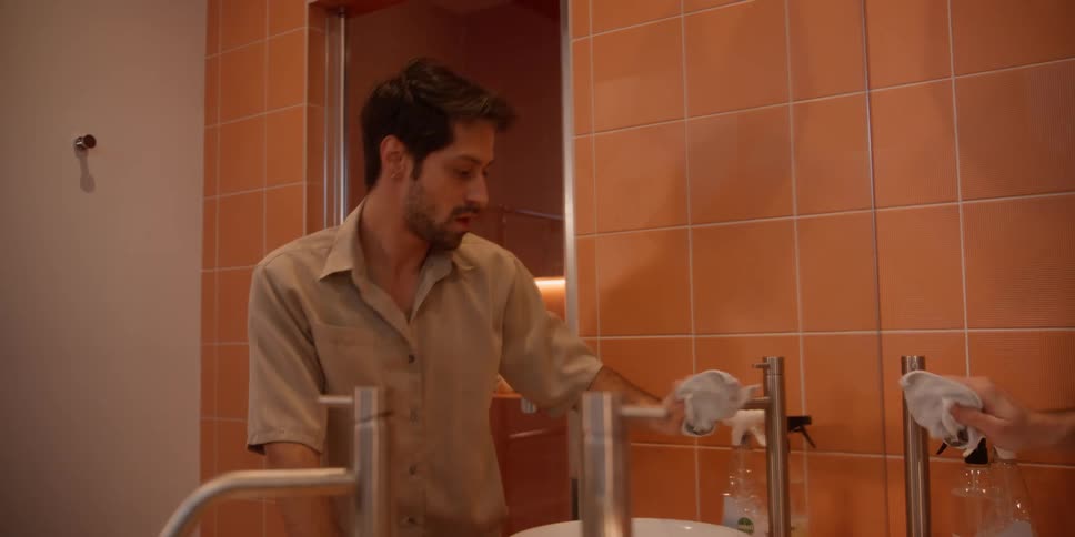 Man mopping the bathroom sink tap and dancing at the same time