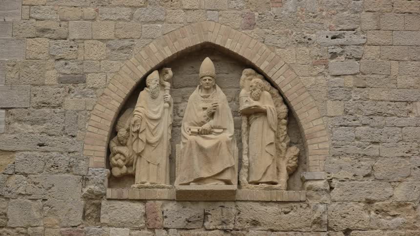 Carved statues are on display on the side of a stone building