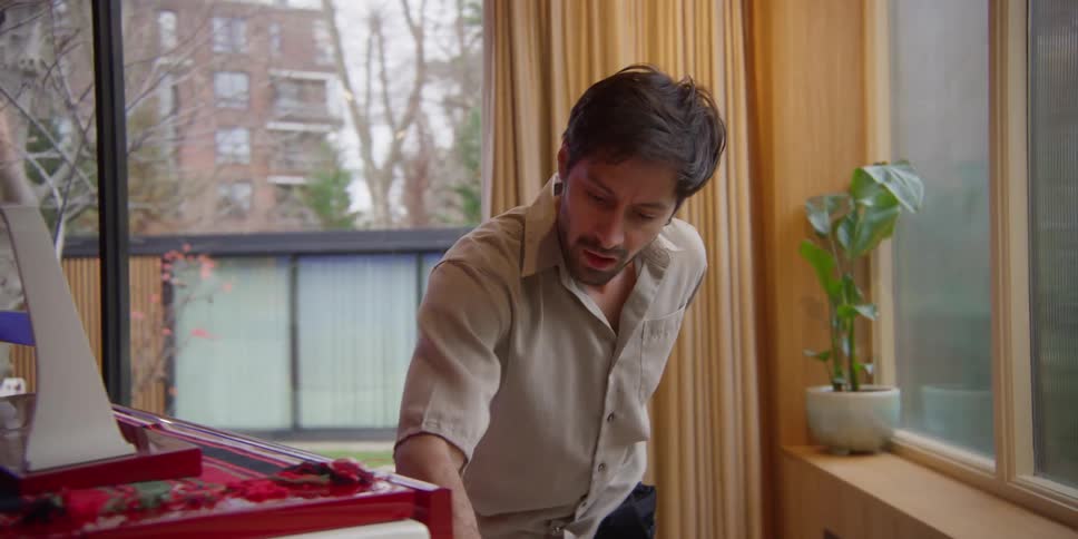 A man dancing while cleaning a piano in a room