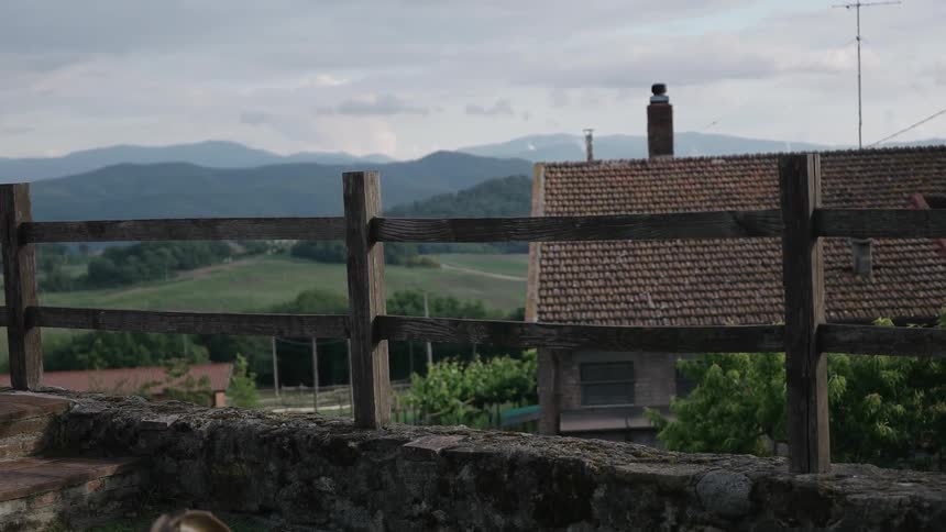 A house behind a fence with mountains in the background