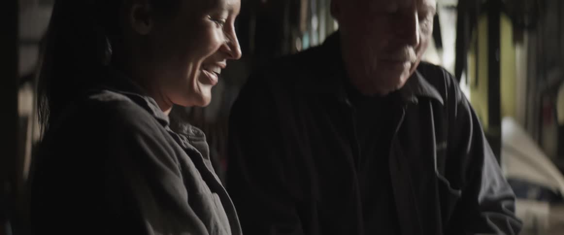 Man lighting a torch while a woman holds a metal piece
