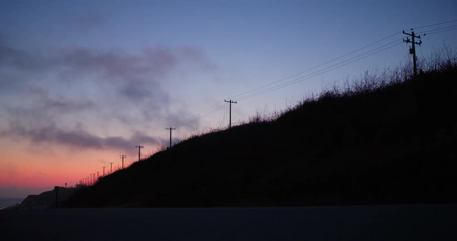 Electricity transmission poles on a red sky day