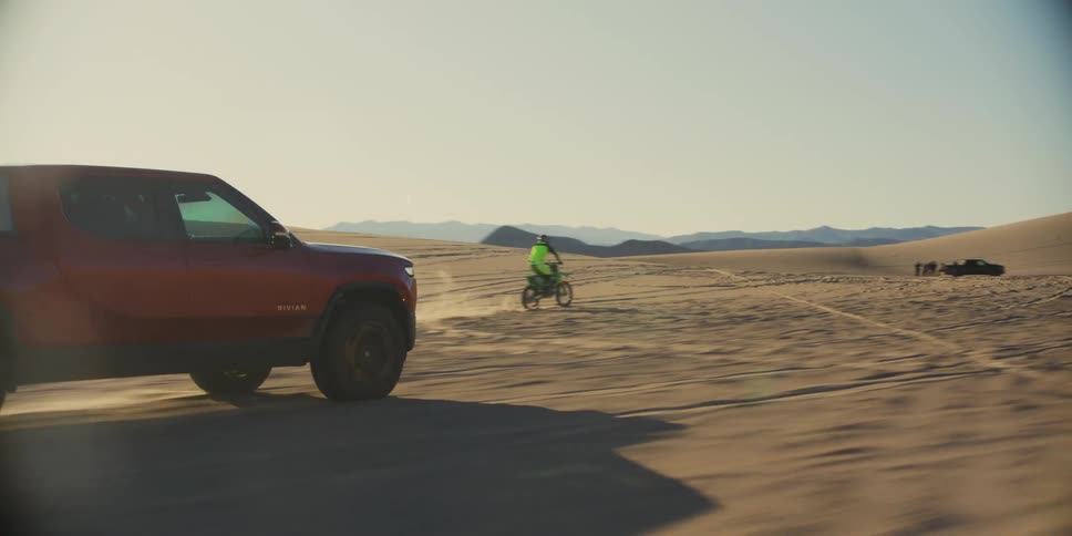 A motorcycle and a pickup truck racing in the desert