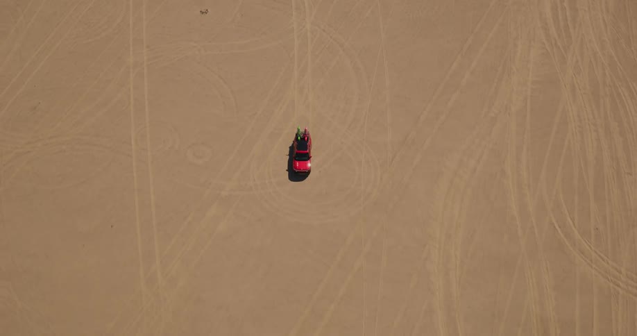 Aerial panorama of a red vehicle traveling through the desert