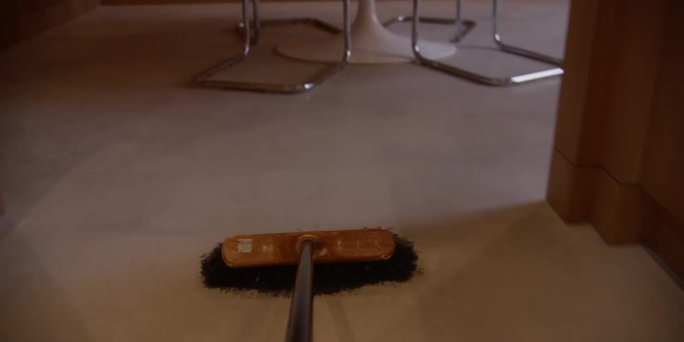 Closeup of a broom sweeping the floor