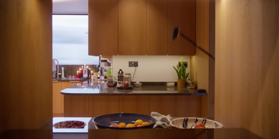 A man runs to the right jumping and comes back jumping into a kitchen