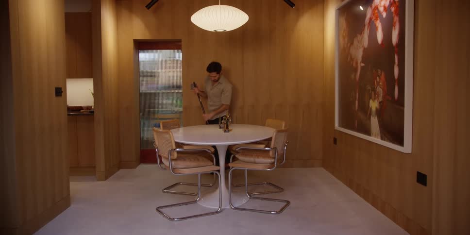 Man passing a broom in an office room
