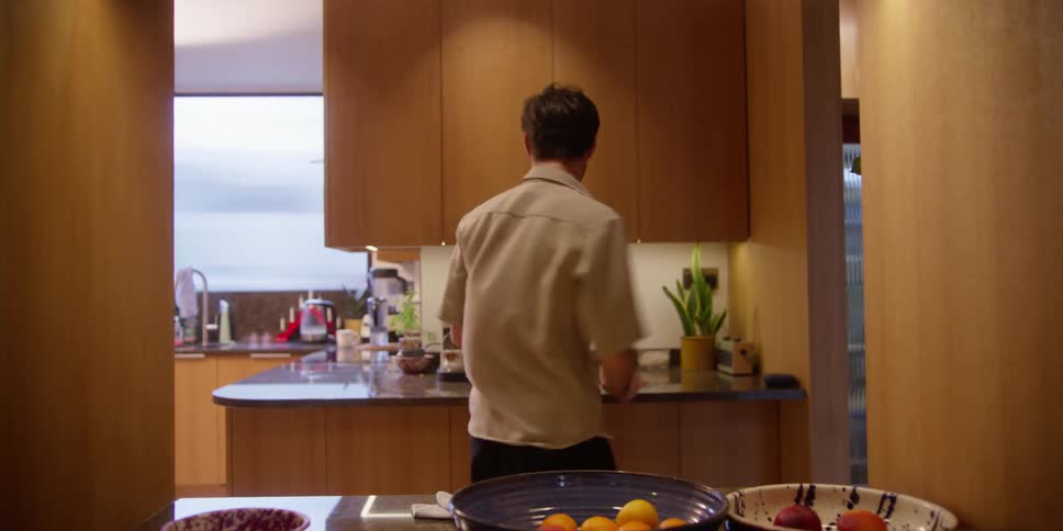 Man dancing around the kitchen while mopping furniture