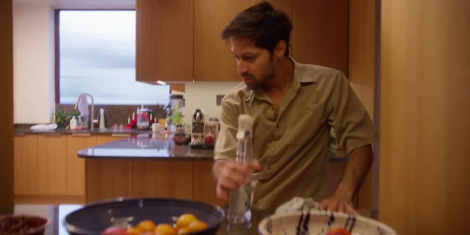 Male dancer dancing in the kitchen while cleaning