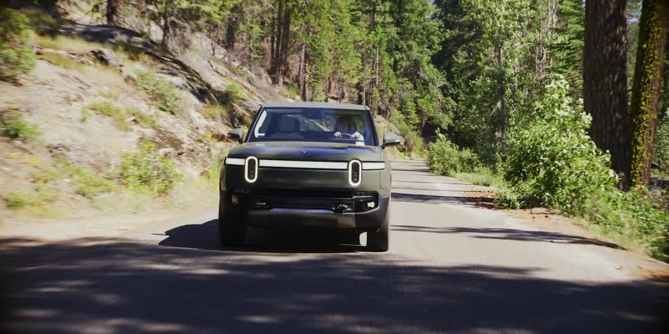 A person driving a car on a forest road during the day