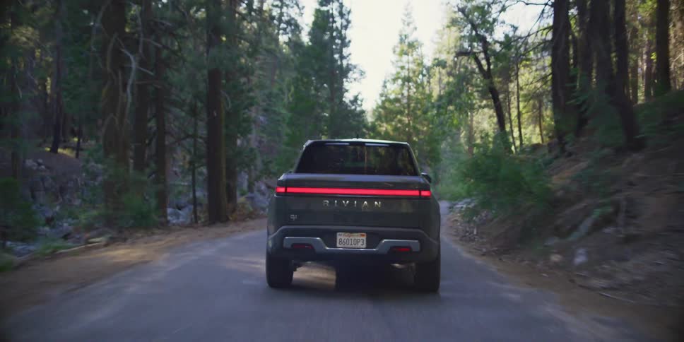 A car driving on a rural road with a forest on the sides