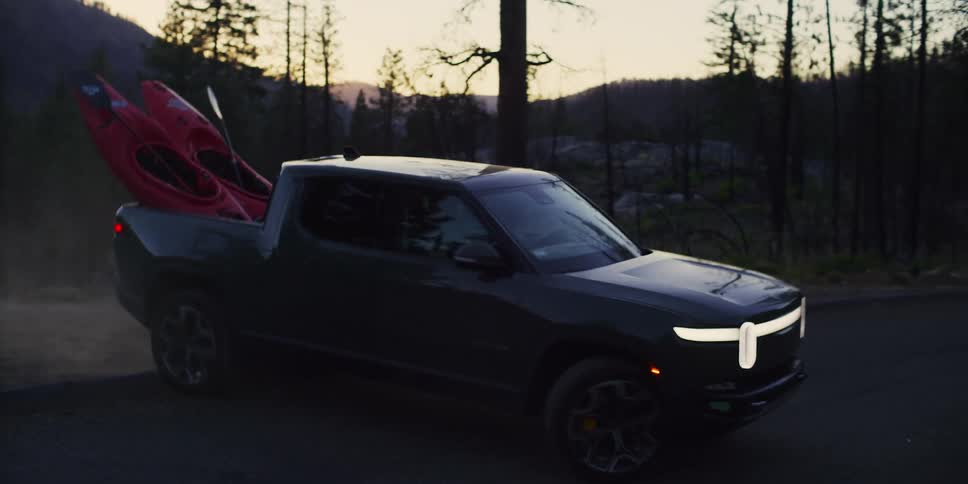People driving a car on a deserted road in the forest during dusk