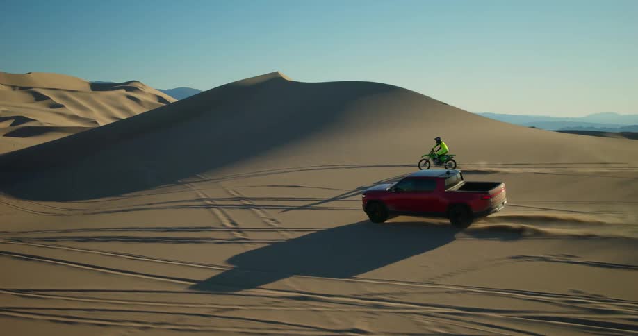 A truck and dirt bikes riding outdoors