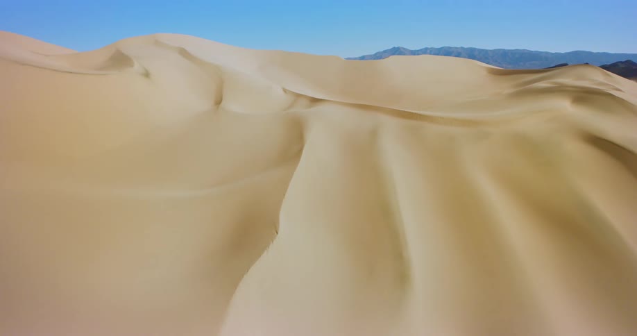 A desert with some sand dunes and the sky is very blue