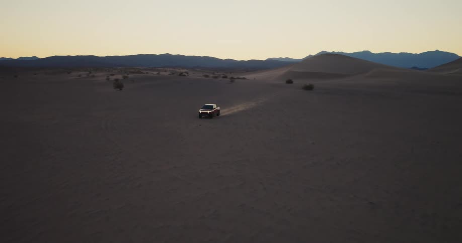 Red truck passing at high speed through the desert