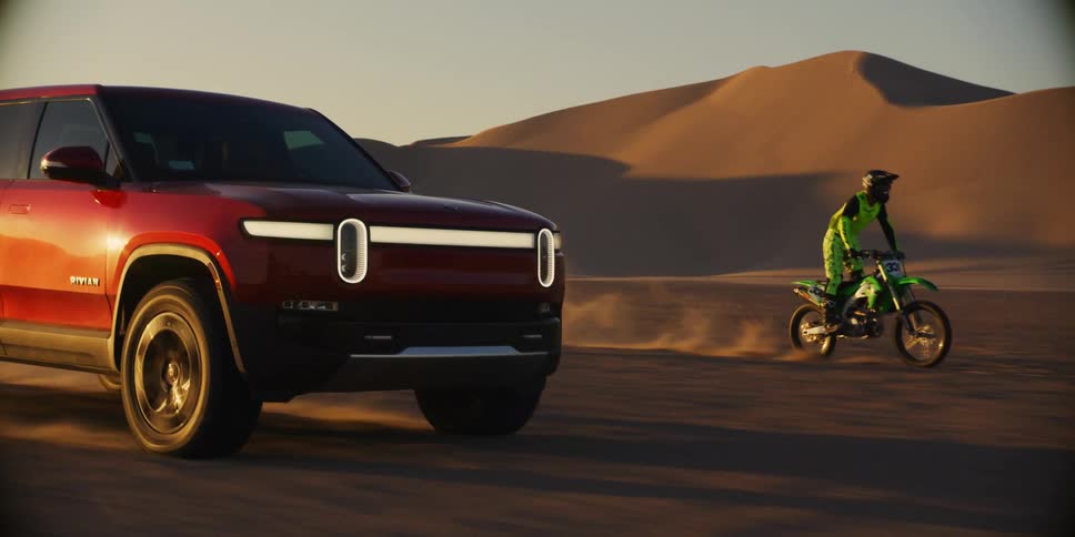 Suv car traveling side by side with a motorbike in the middle of the desert