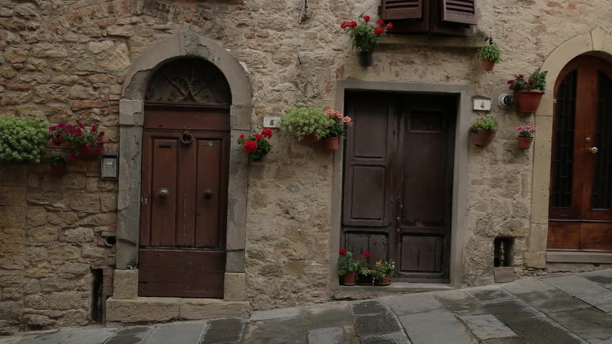 Arched doorways on each side of a square door with a slanted walkway in front of them