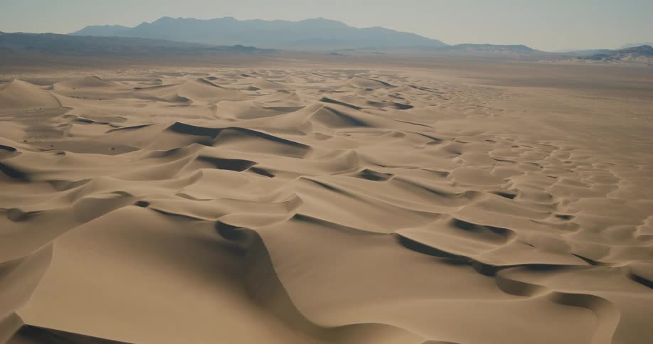 Large dunes in a desert near a mountain range