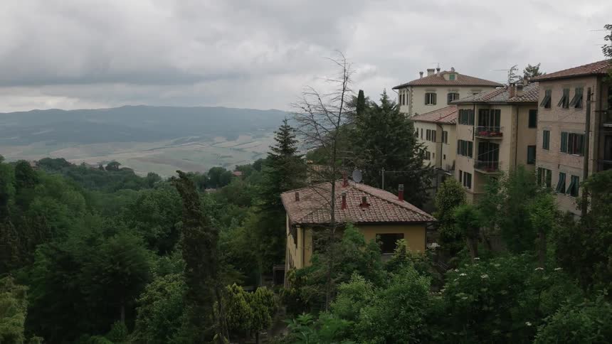 Buildings sitting in a heavily  treed area  on a cloudy day