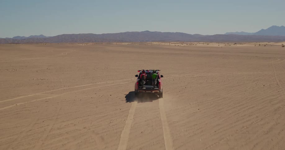 Truck carrying two bucketbrand motorcycles in the middle of the desert