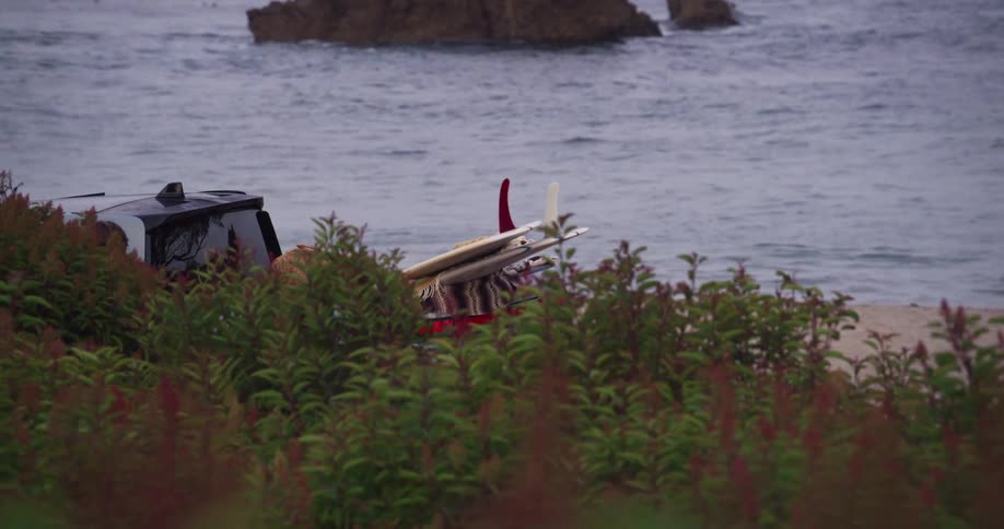 A group of people loading up surfboards