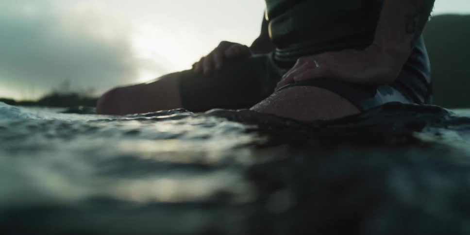 A man floats on a surfboard in the ocean