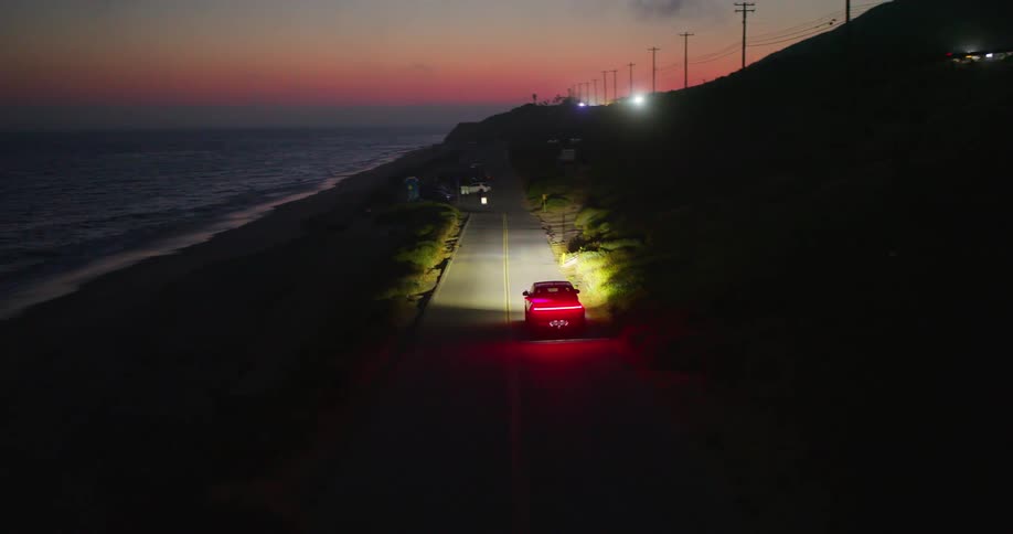 A truck drives on a road near a beach
